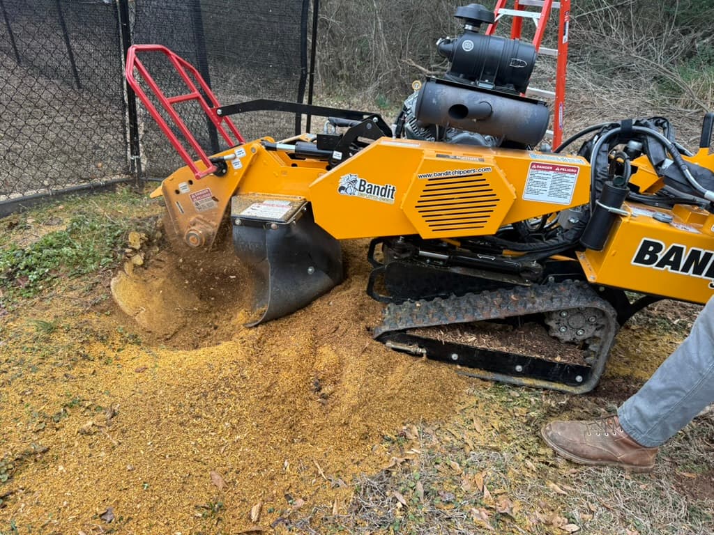 Close-up of Bandit SG-40 grinding stump near fence line with grindings visible